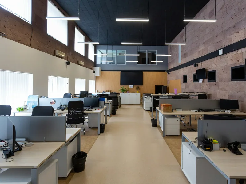 A finished open-plan office with rows of desks, workstations and linear lighting